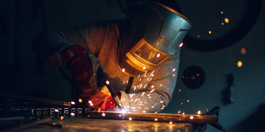 A person wearing a welding hood while working.