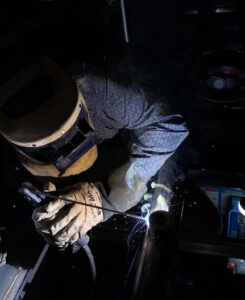 Client browsing through a collection of exotic welding hoods.